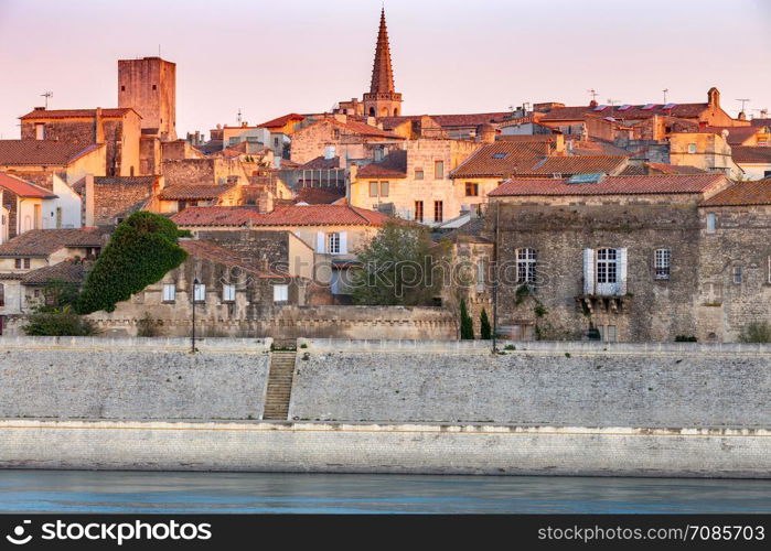 View of the city promenade in the night lights at sunset. Arles. France. Provence.. Arles. City embankment and facades of old houses at sunset.