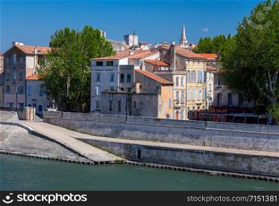 View of the city promenade on a sunny day in Arles. France. Provence.. Arles. City embankment and facades of old houses.