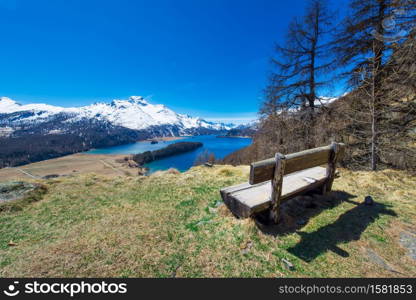 View of the Engadin valley from a wooden bench in spring