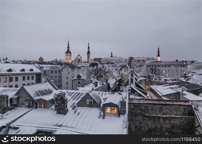 View of the evening, winter Tallinn, roofs of houses, cathedrals and churches of the city with electric lighting