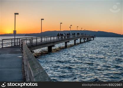 View of the fishing pier in Des Moines, Washington at sunset.