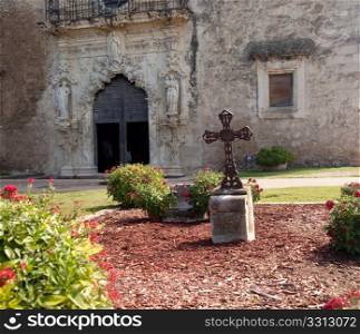 View of the garden and cross in front of the Mission Espada near San Antonio in Texas