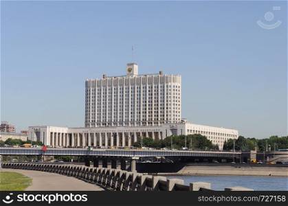 View of the Government House (White House) of the Russian Federation in Moscow. Bridge across the Moscow River. Summer day, blue sky.