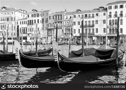 View of The Grand Canal in the Rialto bridge area with moored gondolas, Venice, Italy. Black and white photography