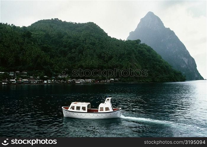 View of the Grand Piton Peak with a boat sailing in the foreground