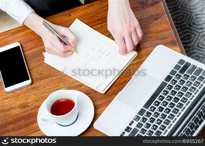 view of the hands at work, writing important information to the notebook