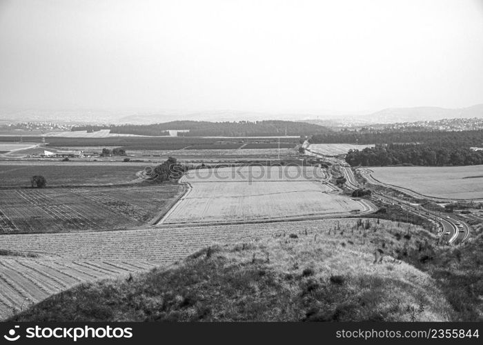 View of the Israeli Golan Heights with vineyards and developed agriculture, Druze cities and paved roads in black and white
