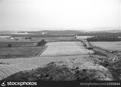 View of the Israeli Golan Heights with vineyards and developed agriculture, Druze cities and paved roads in black and white