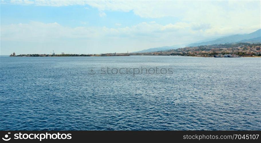 View of the Messina sea strait and coastline from the side of the ferry to Sicily island, Italy. Villa San Giovanni town on shore.