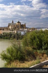 View of the Mosque-Cathedral of Cordoba seen from the south bank of the Guadalquivir river in Spain.