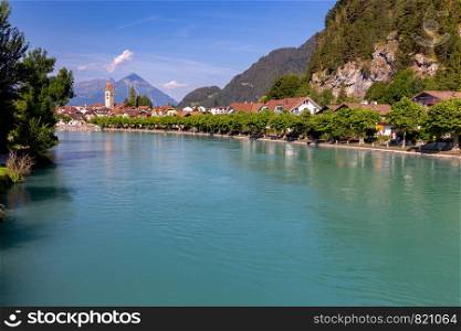 View of the mountain river Aare with turquoise water passing through the city. Interlaken. Switzerland.. Interlaken. Mountain river Aare passing through the city.