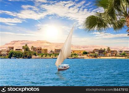 View of the Nile and a sailboat by the Valley of Kings in Luxor, Egypt.. View of the Nile and a sailboat by the Valley of Kings in Luxor, Egypt