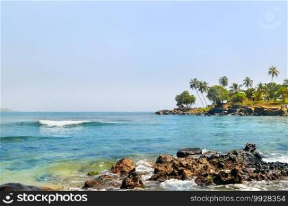 view of the ocean surface and tropical palms on the shore. Concept of romantic time on vacation in tropical.