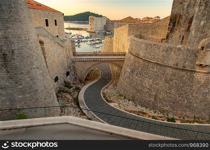 View of the old medieval walls and harbor at dawn. Dubrovnik. Croatia.. Dubrovnik. Old harbor at dawn.