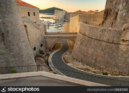 View of the old medieval walls and harbor at dawn. Dubrovnik. Croatia.. Dubrovnik. Old harbor at dawn.