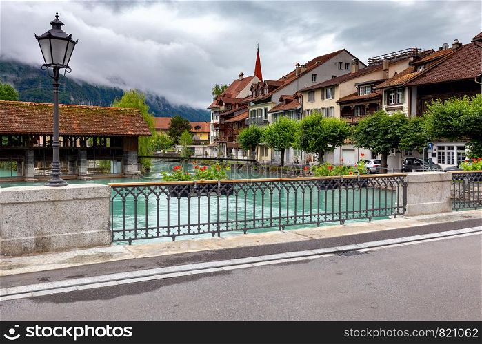 View of the old medieval wooden dam and the mill on the river Aare. Interlaken. Switzerland.. Interlaken. Old wooden dam on the mountain river Aare.