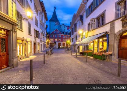 View of the old narrow medieval city street with burning lanterns. Zurich. Switzerland.. Zurich. Old city street in night illumination.
