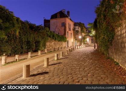 View of the old street on the Montmartre hill in the night lighting. Paris. France.. Paris. Old street on the Montmartre hill.