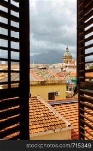 View of the old town of Palermo in Sicily through the open window with shutters, Italy