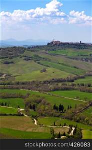 View of the old town Pienza and hill, green fields at sunny day. province of Siena. Tuscany, Italy