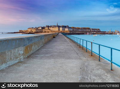 View of the old town with a breakwater at sunset. Saint Malo. Brittany. France.. Saint Malo. View of the old town.