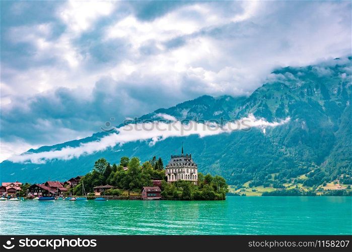 View of the peninsula and former castle and Lake Brienz in swiss village Iseltwald, Switzerland. Swiss village Iseltwald, Switzerland