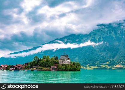 View of the peninsula and former castle and Lake Brienz in swiss village Iseltwald, Switzerland. Swiss village Iseltwald, Switzerland