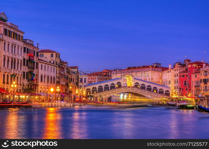 View of the Rialto Bridge and Grand Canal in a blue hour at sunset. Venice. Italy.