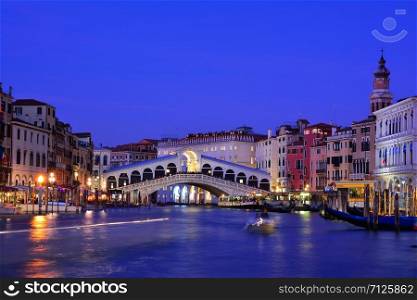 View of the Rialto Bridge and Grand Canal in a blue hour at sunset. Venice. Italy.