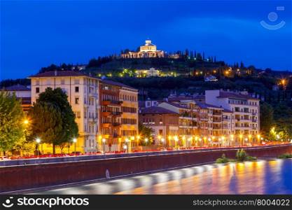 View of the River Adige and the Sanctuary of the Madonna of Lourdes at sunset.. Verona. Adige river embankment at night.