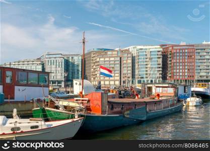View of the River Amstel, houses and barges on a sunny day . Netherlands.