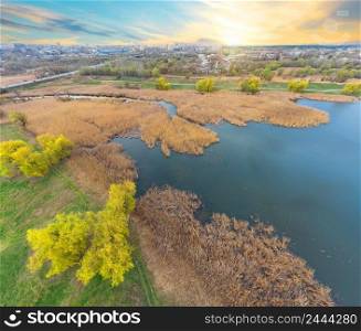 View of the river and the green bank from a height at sunset. Photo from a quadcopter. View of river and green bank from height at sunset