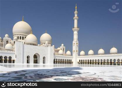 View of the Sahan courtyard with minaret and the main dome of the Sheikh Zayed Grand Mosque in Abu Dhabi, UAE