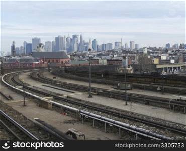 view of the skyline of New York City behind the tracks of the subway