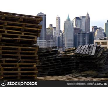 view of the skyline of New York City with staples of pallets in the foreground