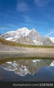 View of the south side of Mont Blanc reflected in a small alpine lake. Val Veny, Italy