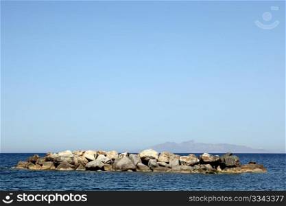 View of the stone breakwater volcanic beaches of Santorini island, Greece.. Seascape. Santorini island, Greece.