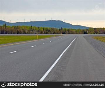View of the Trans-Canadian Highway with electric wind mill towers in the background.