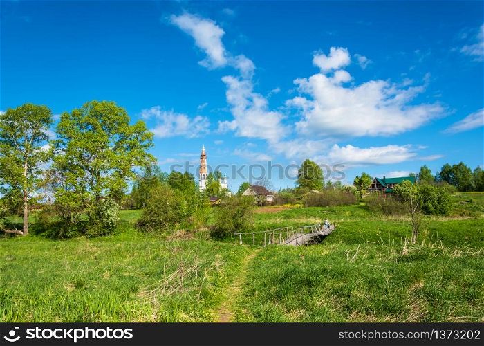 View of the village of Mikhailovskoye with views of the Church of the Holy Archangel Michael and the bodiless hosts on a Sunny spring day.