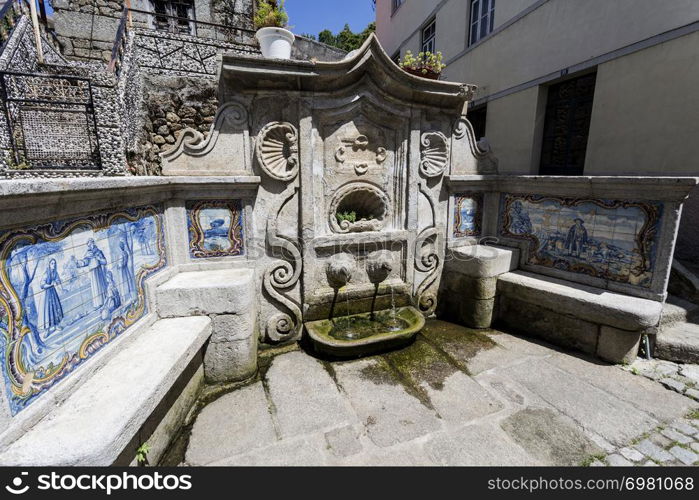 View of the water fountain, Fonte do Assento, built in late Baroque rococo style with stone benches and panels of traditional blue tiles, in Gouveia, Beira Alta, Portugal