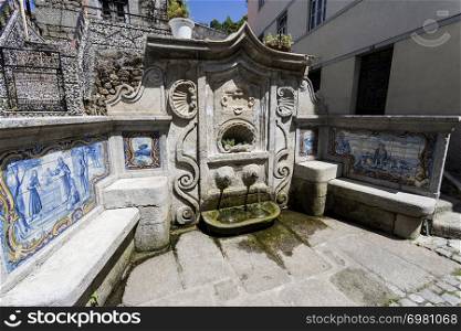 View of the water fountain, Fonte do Assento, built in late Baroque rococo style with stone benches and panels of traditional blue tiles, in Gouveia, Beira Alta, Portugal