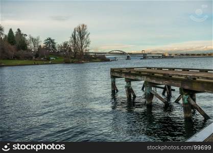 View of the west end of the 520 bridge in Seattle. Lake Washington with a pier is in the foreground