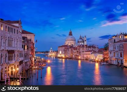 View of Venice Grand Canal with boats and Santa Maria della Salute church in the evening from Ponte dell’Accademia bridge. Venice, Italy. View of Venice Grand Canal and Santa Maria della Salute church in the evening