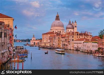 View of Venice Grand Canal with boats and Santa Maria della Salute church on sunset from Ponte dell’Accademia bridge. Venice, Italy. View of Venice Grand Canal and Santa Maria della Salute church on sunset