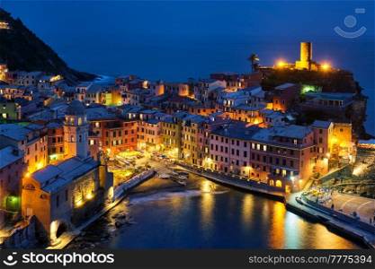 View of Vernazza village popular tourist destination in Cinque Terre National Park a UNESCO World Heritage Site, Liguria, Italy view illuminated in the night from Azure trail. Vernazza village illuminated in the night, Cinque Terre, Liguria, Italy