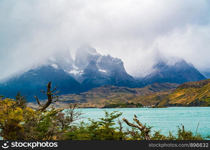 View of View of Cuernos del Paine covered with fog and lake Pehoe in Torres del Paine National Park, Chile