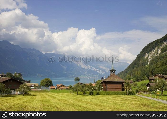View of wooden church at Iseltwald with a lake and mountain, in switzerland
