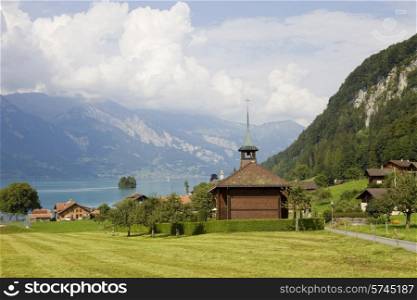 View of wooden church with a lake and mountain at switzerland