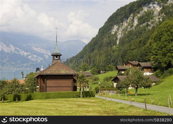 View of wooden church with a lake and mountain at switzerland