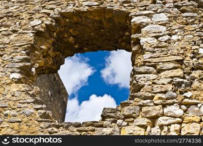 View on a Cloudy Blue Sky through the Hole in the Wall of the Fortress of Saint Montan